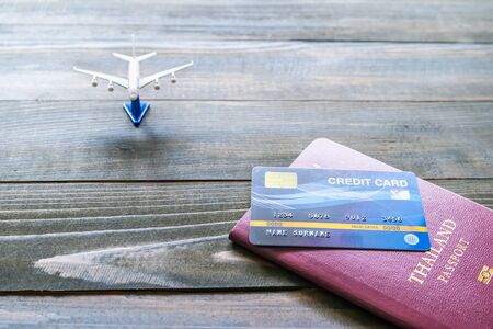 Passport with  credit card on brown wooden desk background, Preparation for Traveling conceptの写真素材