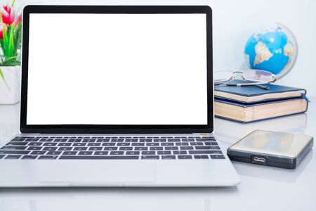 Laptop mockup with blank screen and Eye glasses on book and simulated world on table