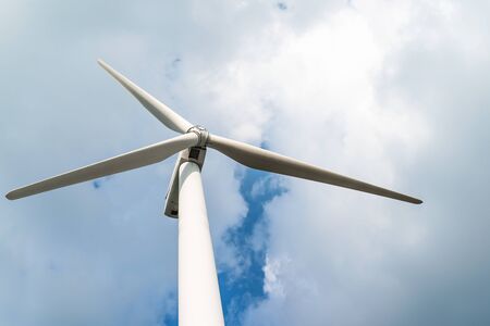 Close up Wind turbine  generators against a cloudy blue sky