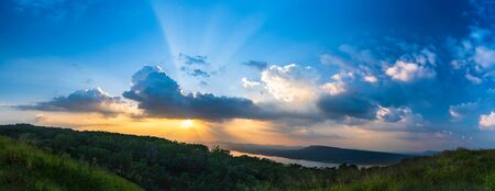 Panorama Sunset with ray light on clouds in a blue and orange sky in twilight timeの写真素材