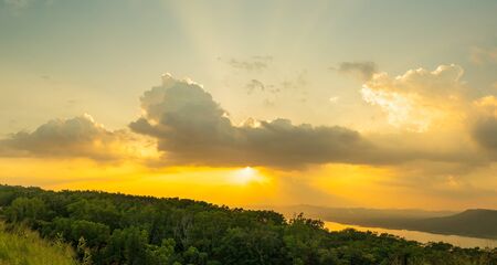 Sunset with ray light on clouds in a blue and orange sky in twilight timeの写真素材