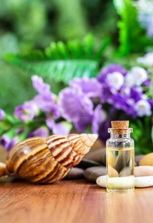 Snail and Bottle collagen or serum oil with flower backgroundの写真素材