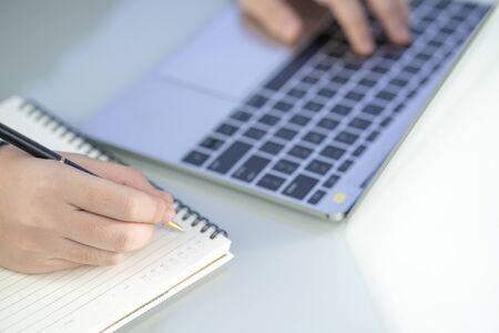 Woman working at home office using laptop searching web, browsing information ,Hand on keyboard close upの写真素材