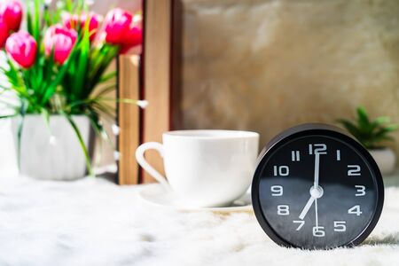 Black clock and cup of coffee ,Coffee time in the morningの写真素材