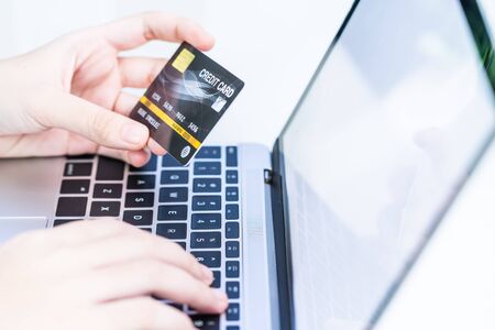 Close up of female hands making online payment, Woman hands holding a credit card and using laptop...