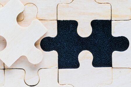 Close up Shot of wooden jigsaw puzzle pieces on black background,Business conceptの写真素材