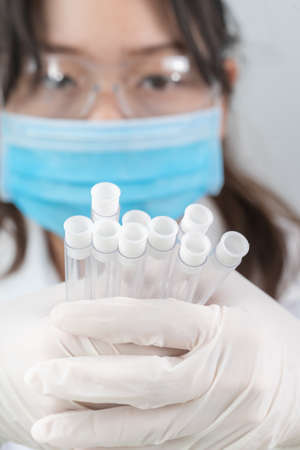 Technician scientist analyzing holding test tube in laboratory for testing it on COVID, COVID-19,...