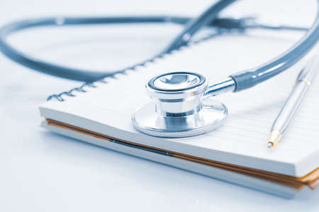 Close up stethoscope on blank notepad as medical conceptの写真素材