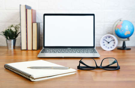 Glasses and notepad with Blank screen laptop computer on deck, Workplace with laptop on table at home,Work form home conceptの写真素材