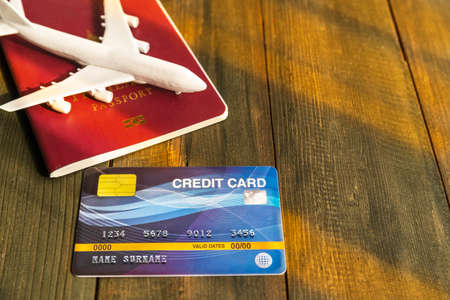 Credit card put on  wooden desk with passport and plan, Preparation for Traveling conceptの写真素材