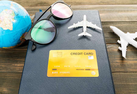 Credit card and airplane model on wooden table , Preparation for Traveling conceptの写真素材