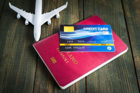 Credit card put on passport and airplane model on wooden table , Preparation for Traveling conceptの写真素材