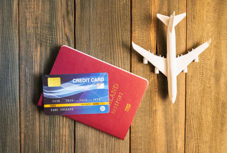 Credit card put on passport and airplane model on wooden table , Preparation for Traveling conceptの写真素材