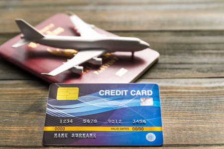 Credit card put on  wooden desk with passport and planの写真素材