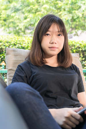 Young girl studying online from digital tablet on the sofai n living room at homeの写真素材