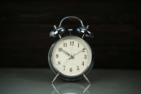 Retro alarm clock on table near wood backgroundの写真素材