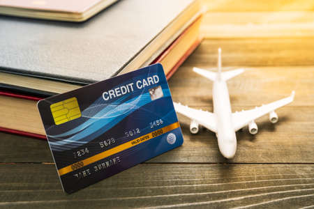 Credit card and airplane model on wooden tableの写真素材