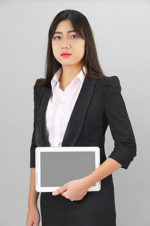 Young women standing in suit holding her digital tablet computorの写真素材