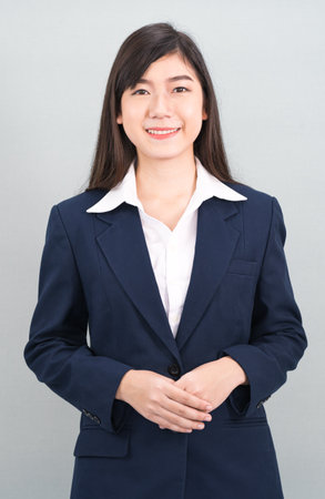 Portrait of asian business woman standing isolated on gray backgroundの写真素材
