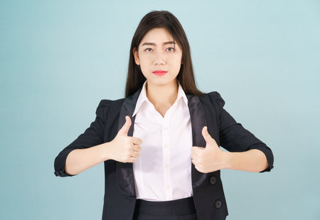 Asian business women in suit and thump up hand signの写真素材