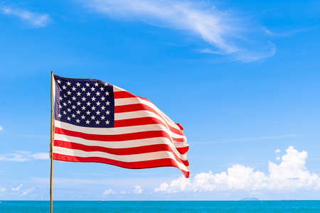 Flag of United States of America (USA) waving in the wind with blue sky and cloud on a sunny dayの写真素材