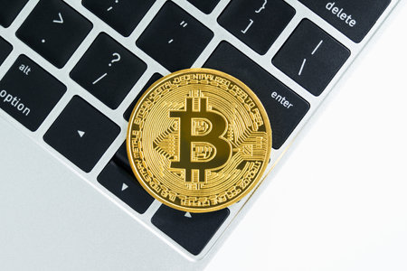 Golden Bitcoins coin on keyboard computer. Close up of metal shiny bitcoin crypto currency coinsの写真素材