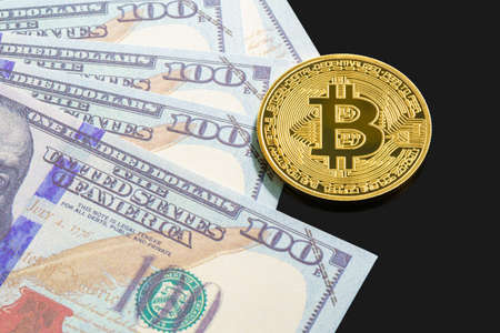 Golden Bitcoins coin and  US banknotes of one hundred dollars. Close up of metal shiny bitcoin crypto currency coins and US dollarの写真素材