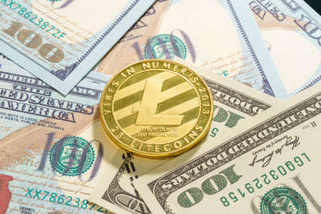 Golden Litecoins coin and  US banknotes of one hundred dollars. Close up of metal shiny bitcoin crypto currency coins and US dollarの写真素材