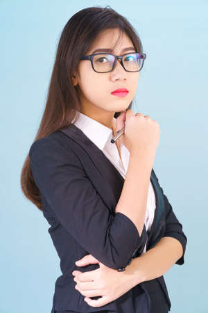 Teenage young asian wearing suit with support hand on chin isolatedの写真素材