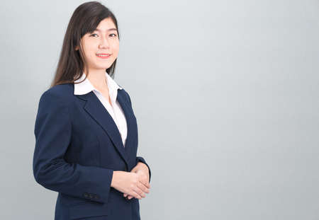 Portrait of asian business woman standing isolated on gray backgroundの写真素材