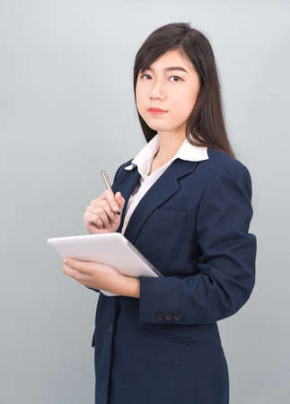 Woman in suit using computer digital tablet isolate on gray backgroundの写真素材