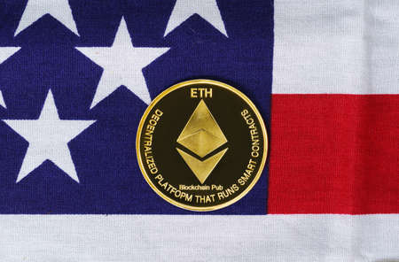Crypto currency concept. Gold Ethereum coin on flag of United States of America USAの写真素材
