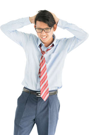 Young man  wearing blue shirt and red tie touching his temples and having headache isolated on white backgroundの写真素材