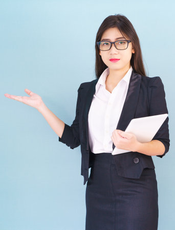 Young women standing in suit holding her digital tablet computor with finger pointing upの写真素材