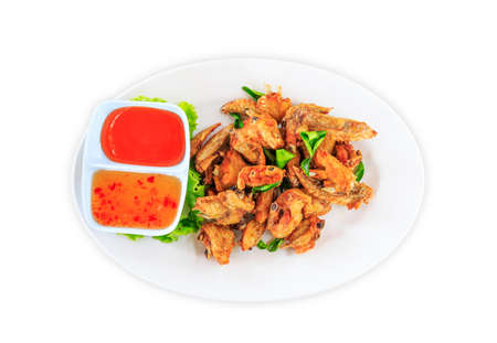 Fried chicken wings with sauce in white plate on white backgroundの写真素材