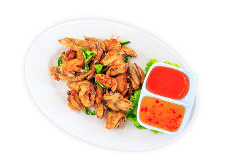 Fried chicken wings with sauce in white plate on white backgroundの写真素材
