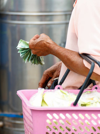 Close up of an elderly woman's hands holding money