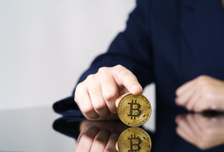 Close-up of finger touching golden bitcoin coin. Cryptocurrency and future money concept
