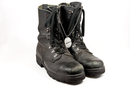 Picture of some old army boots with a dog-tag hangingの写真素材