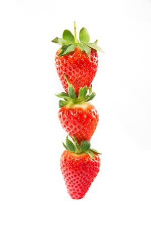 A picture of three strawberries stacked on top of eachotherの写真素材