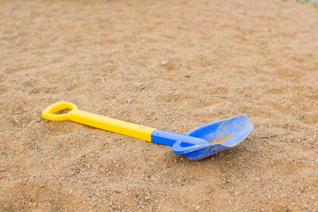 Children39s shovel lying on the sand on the playgroundの写真素材