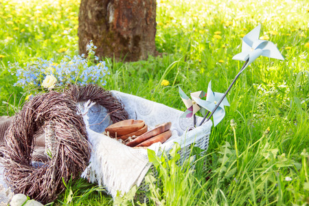 Wooden hearts and plates lie in a basket with braided wreaths made of branches on a picnic. decorationsの写真素材