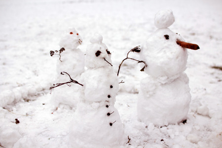 Snowmen standing in the snowの写真素材