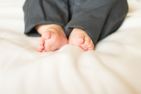 Cute little baby foot on white blanketの写真素材