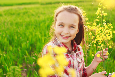 little girl in the field with flowers. portraitの写真素材