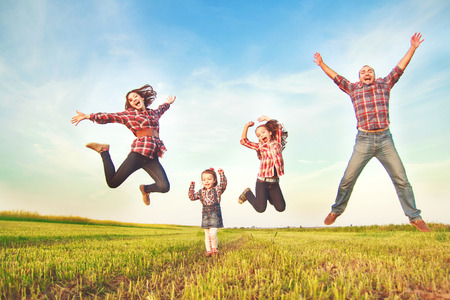 family jumping together in the fieldの写真素材