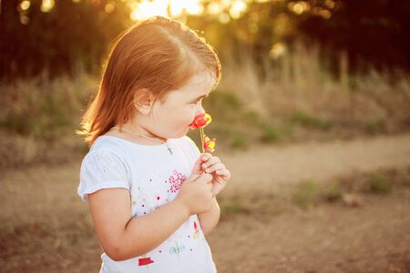 little girl with a flower in the handsの写真素材