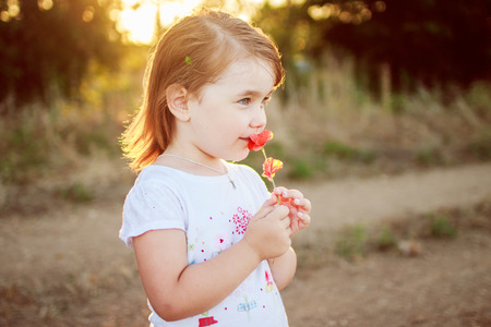little girl with a flower in the handsの写真素材