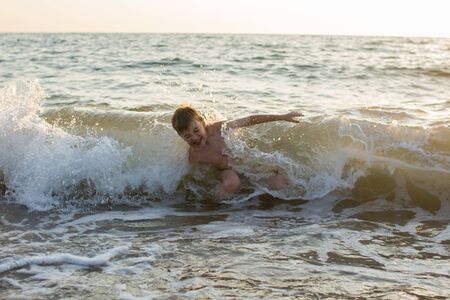 boy swimming in the sea on the wavesの写真素材