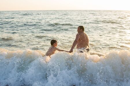 father with son swimming in the seaの写真素材